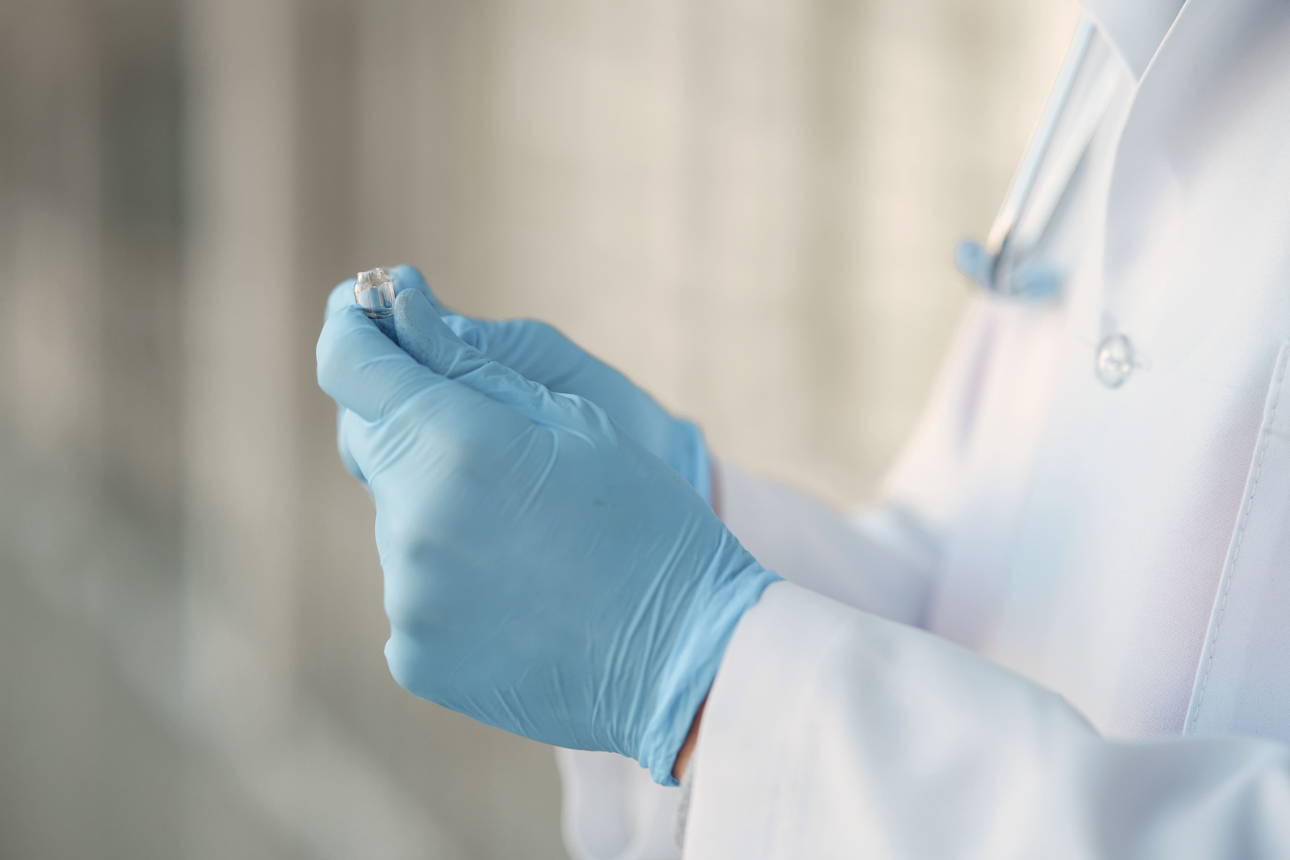 Mão segurando ampola de cemiplimabe 